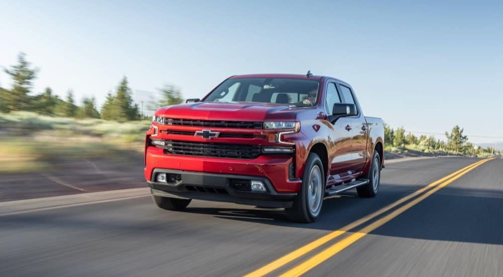 A red 2020 Chevy Silverado 1500 Z71 is shown driving on an open road after leaving a Chevy dealer.