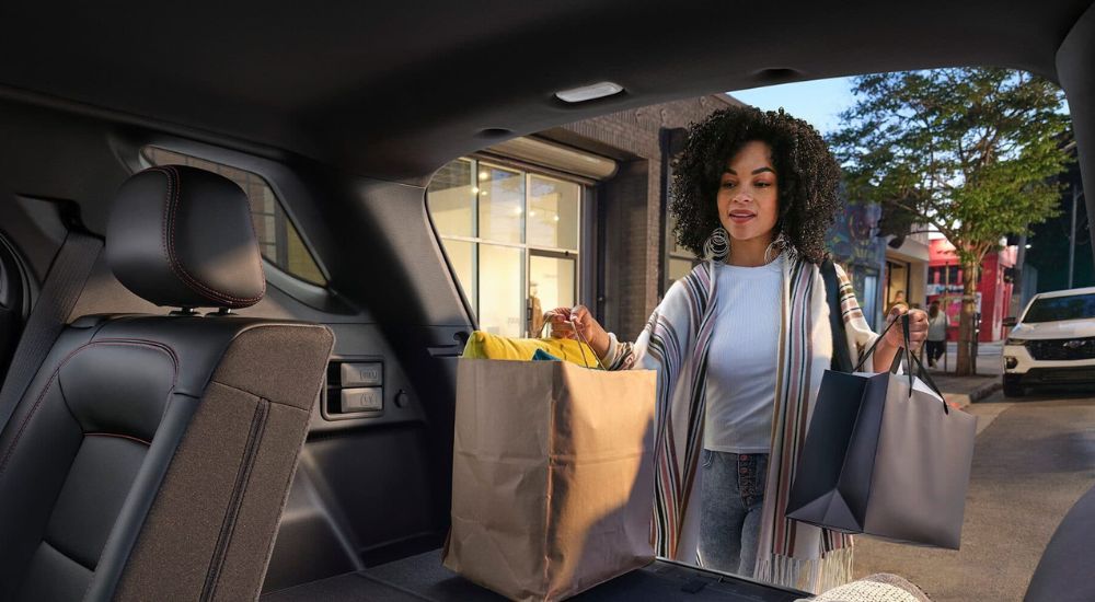 A person is shown loading bags into a 2024 Chevy Equinox.