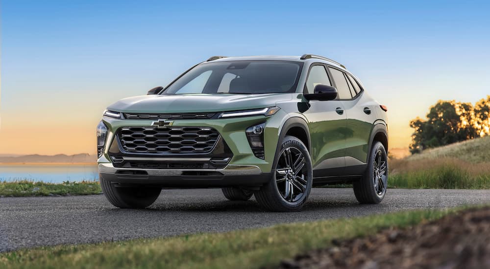 A green 2024 Chevy Trax ACTIV is shown driving from a Chevy dealer in Plymouth.