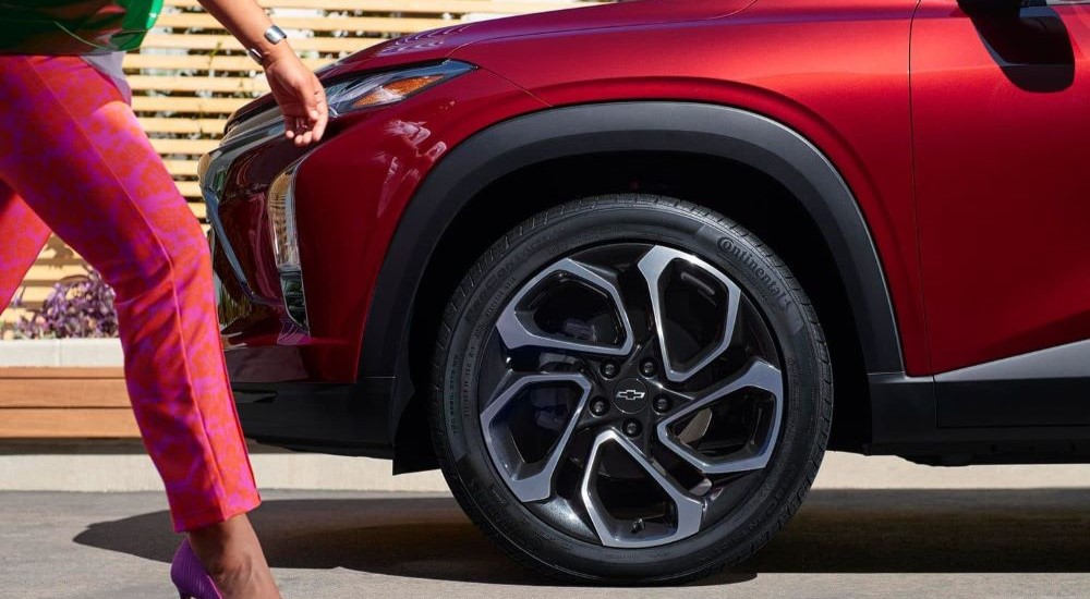 A close-up on the front wheel of a red 2024 Chevy Trax RS is shown.