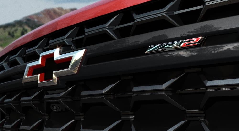 A close-up on the grille and badge of a red 2024 Chevy Silverado 3500HD ZR2.