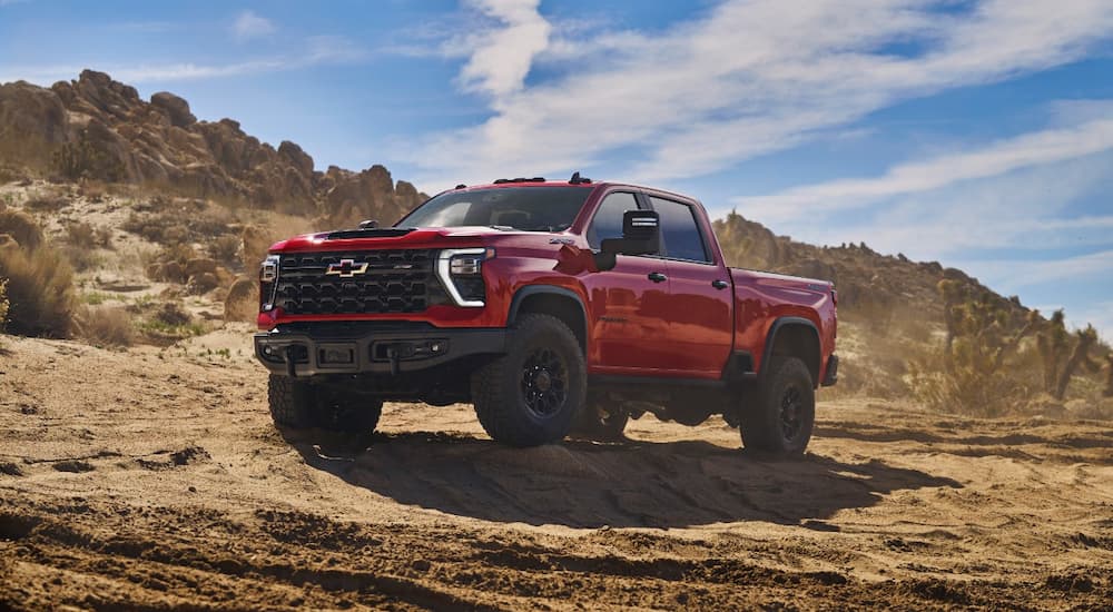 A red 2024 Chevy Silverado HD ZR2 Bison parked in the desert.