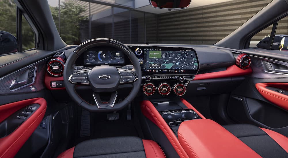 The red interior of a 2024 Chevy Blazer EV for sale is shown from the driver's seat.