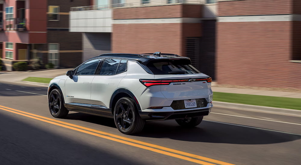 Rear view of a white 2025 Chevy Equinox EV driving.