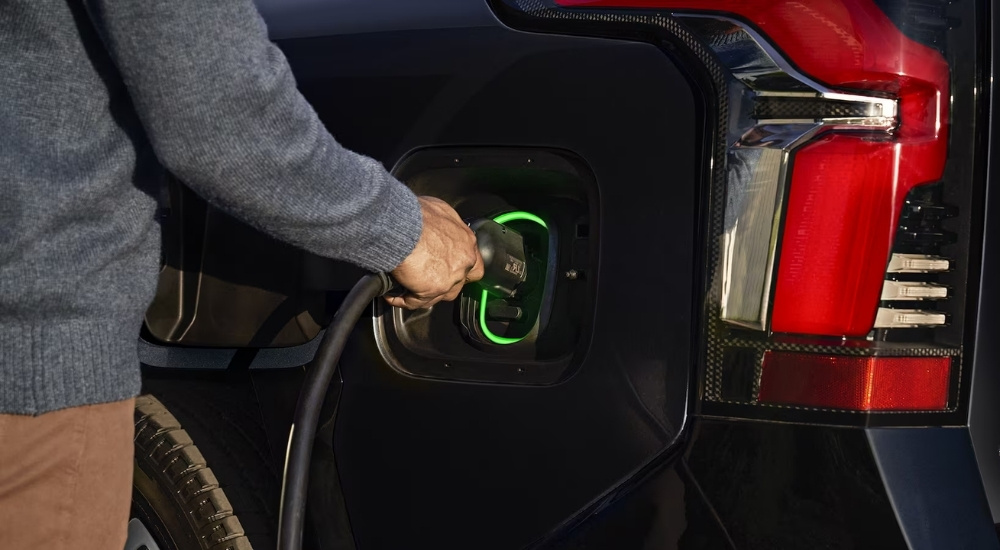 Close-up of a man plugging in a 2024 Chevy Silverado EV.