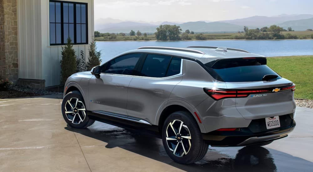 A silver 2024 Chevy Equinox EV for sale is parked on a driveway.