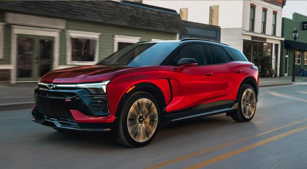 A red 2025 Chevy Blazer EV driving on a city street.