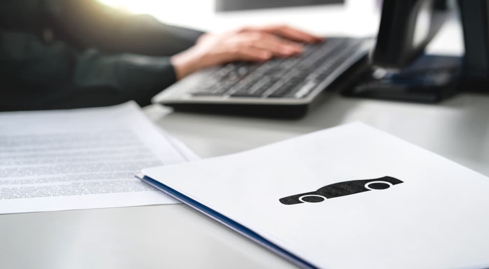 Salesman using a computer at a car dealership