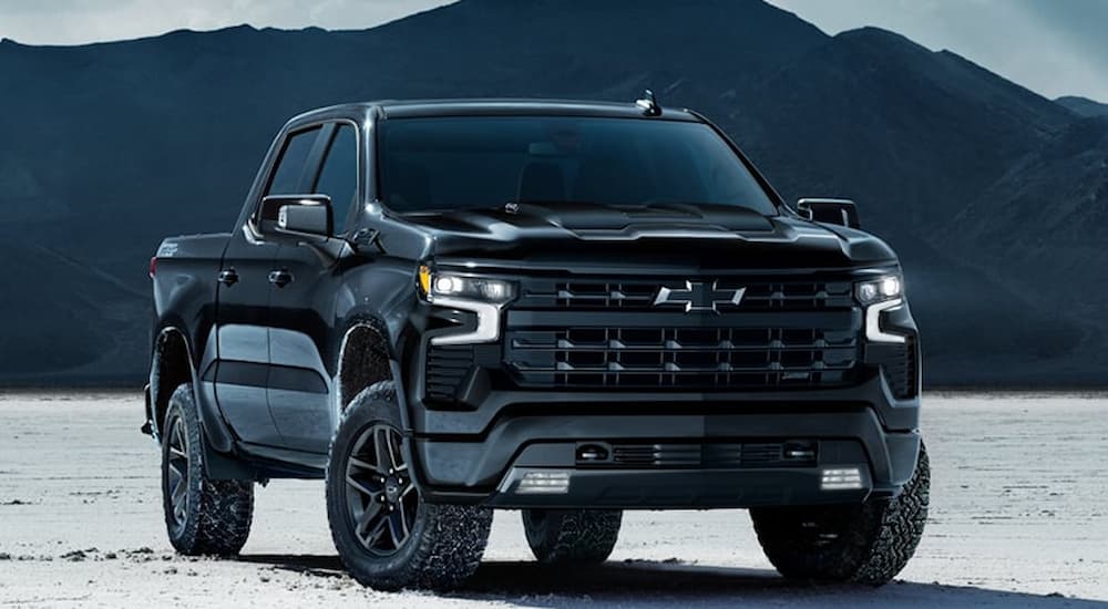 Black 2026 Chevy Silverado 1500 parked off-road after visiting a car dealership.