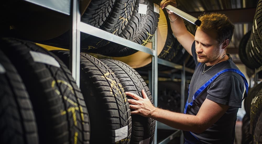 A technician looking at tires in a tire shop.