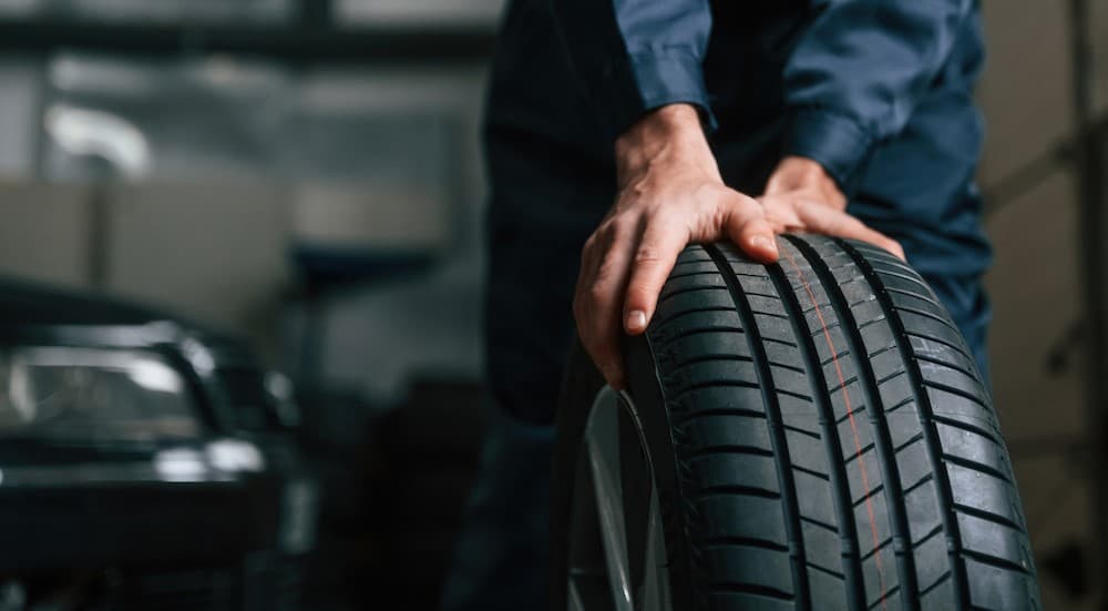 A technician pushing a tire.