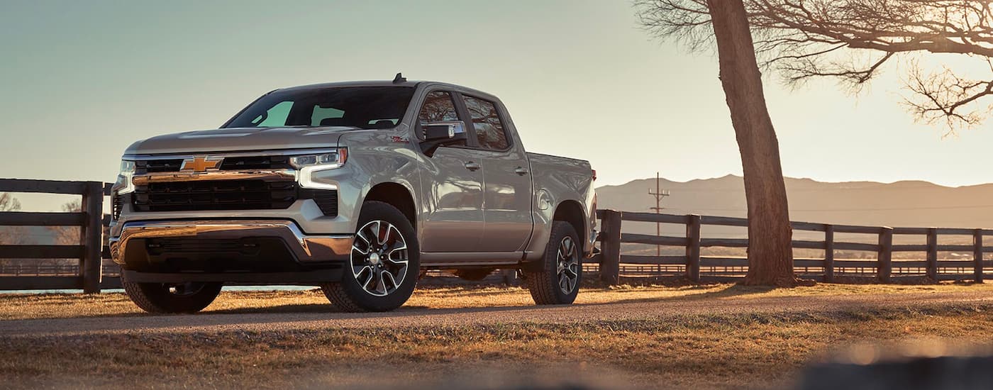 Silver 2023 Chevy Silverado 1500 parked by a white fence