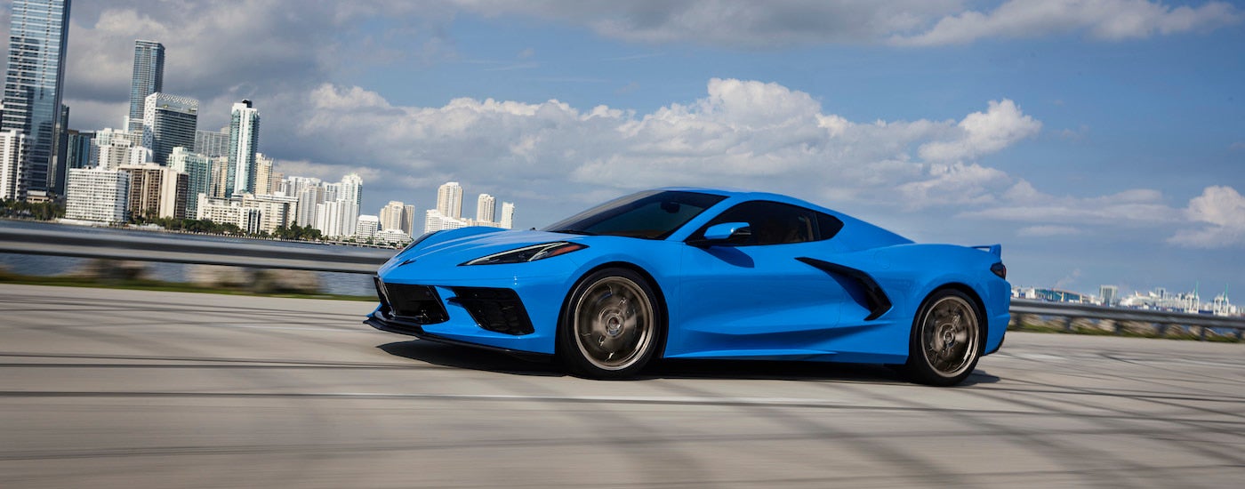 A blue 2024 Chevy Corvette is shown from the side.