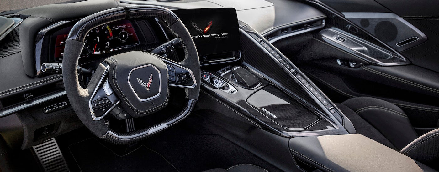 The grey interior of a 2024 Chevy Corvette for sale is shown from the driver's side.