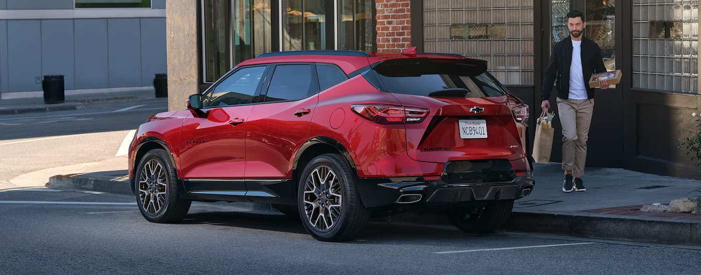 Rear of a red 2026 Chevy Blazer parked by a curb.