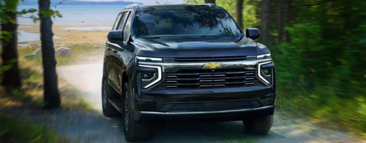 Black 2025 Chevy Tahoe driving away from a beach