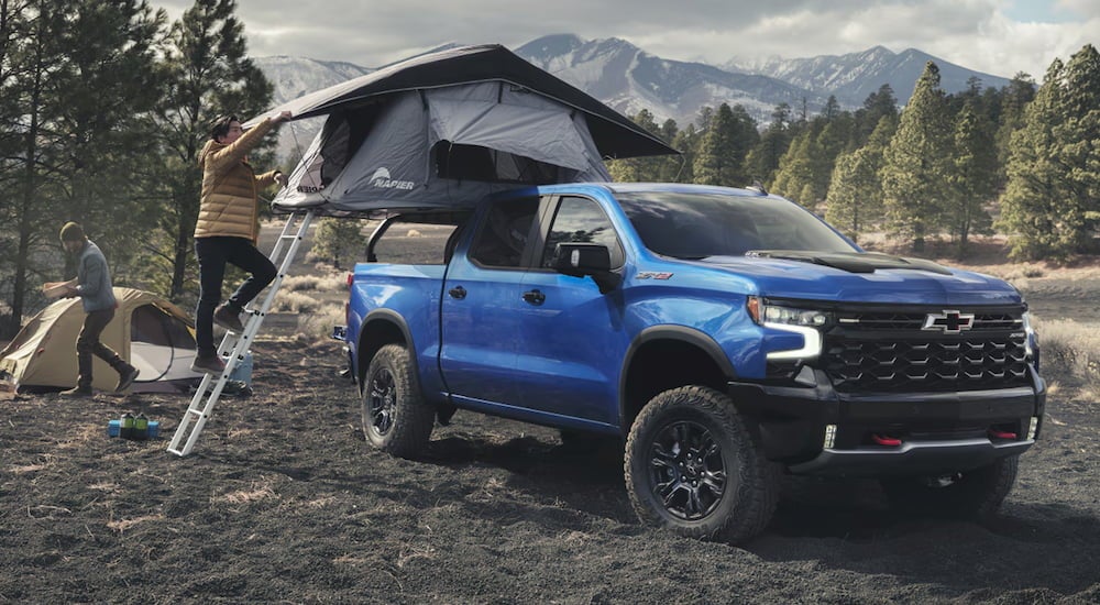 Blue 2026 Chevy Silverado 1500 ZR2 parked off-road with a tent over its bed.