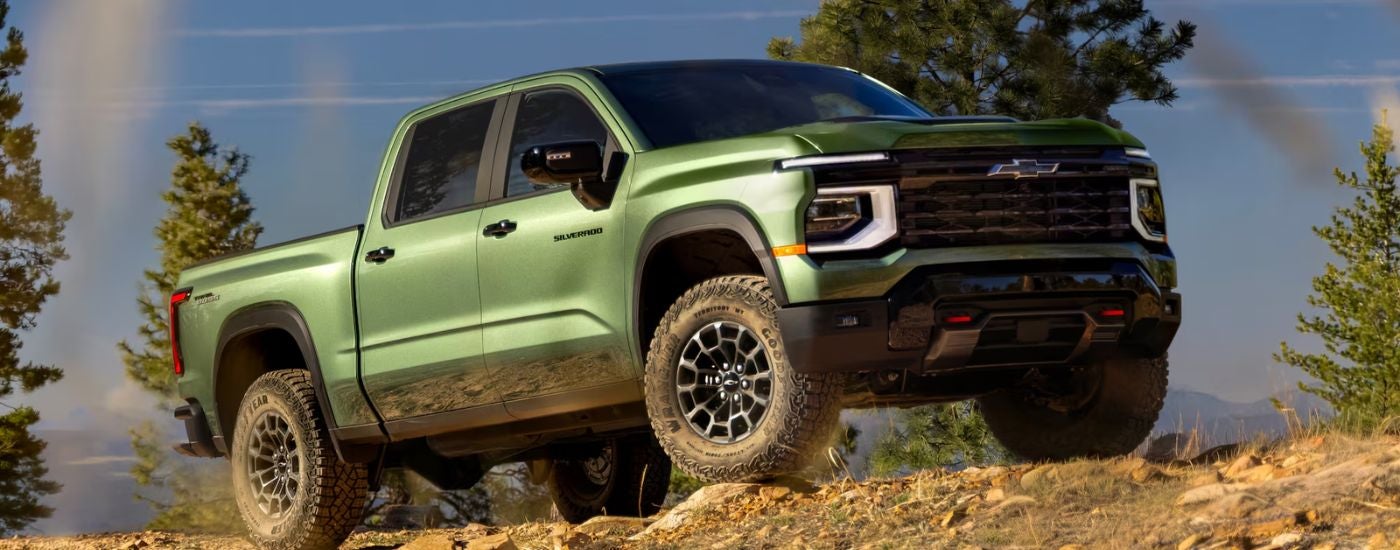 Green 2027 Chevy Silverado 1500 parked off-road at an angle
