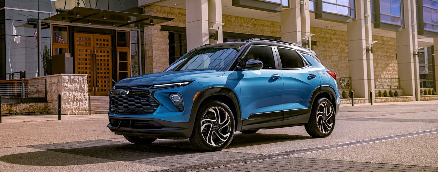 Blue 2025 Chevy Trailblazer RS driving down a city street.
