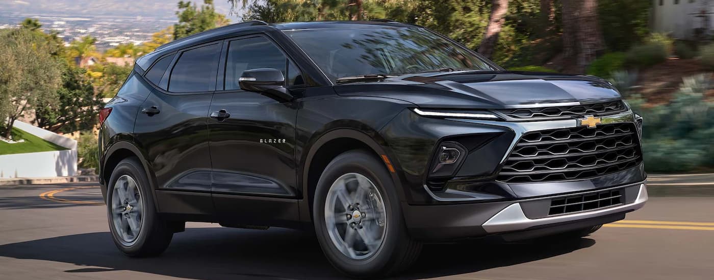 A black 2023 Chevy Blazer is shown driving up a city road after leaving a Chevy Blazer.