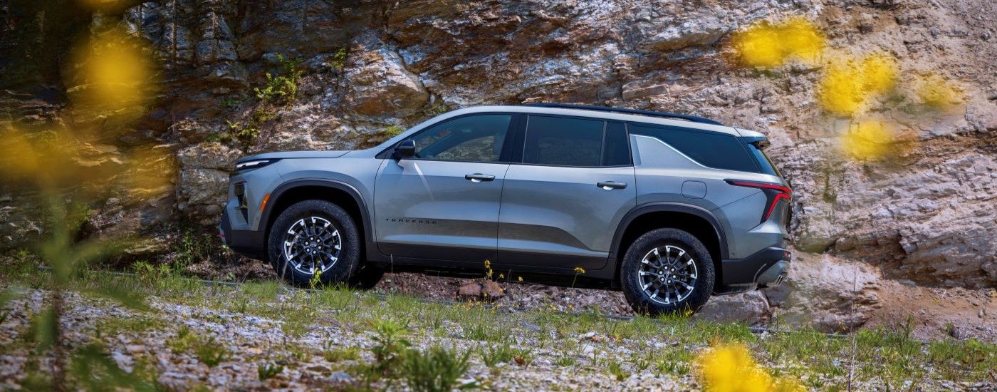 Side angle view of a grey 2024 Chevy Traverse Z71 parked on a field after visiting a Chevy dealer near South Lyon.