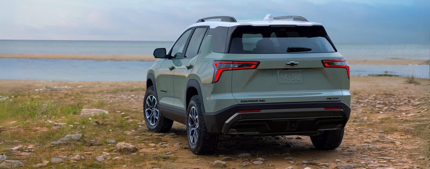 Rear view of a green 2025 Chevy Trax ACTIV parked in a parking spot.