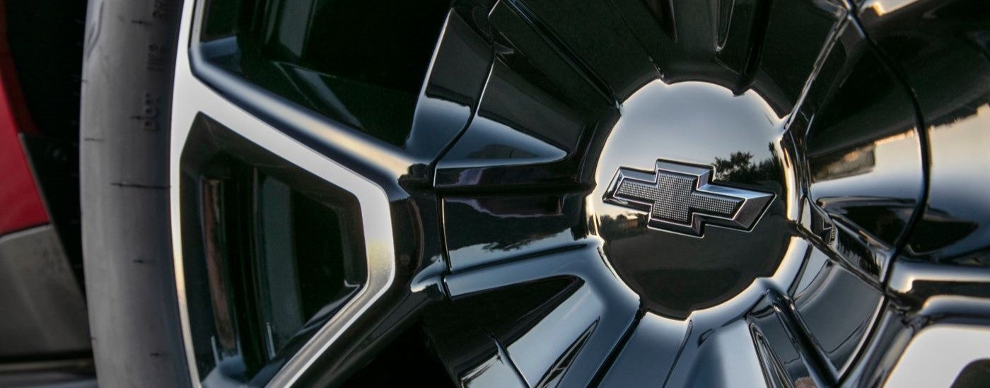 A close up shows a chrome and black wheel on a red 2021 Chevy Tahoe RST.